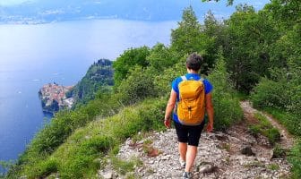 Persona che percorre il Sentiero del Viandante con panorama su Varenna