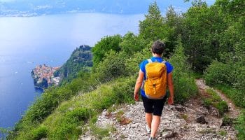 Persona che percorre il Sentiero del Viandante con panorama su Varenna