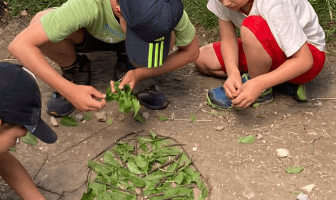 Bambini che giocano con rami e foglie durante una caccia al tesoro archeologica